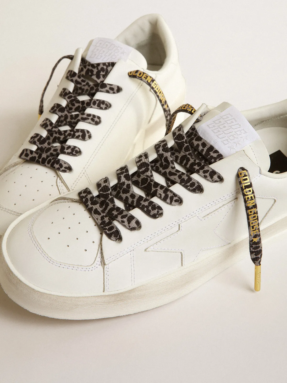 Black and white animal-print laces with contrasting gold-colored logo