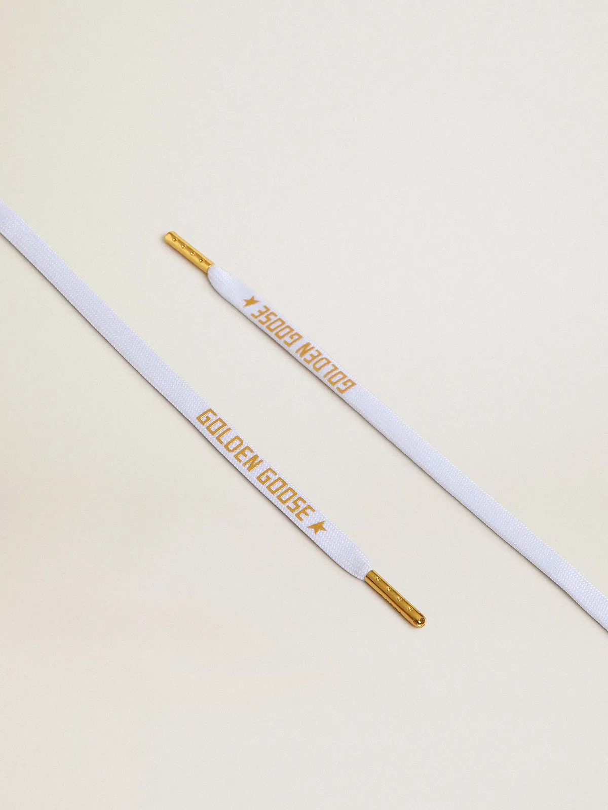 White cotton laces with contrasting gold-colored logo